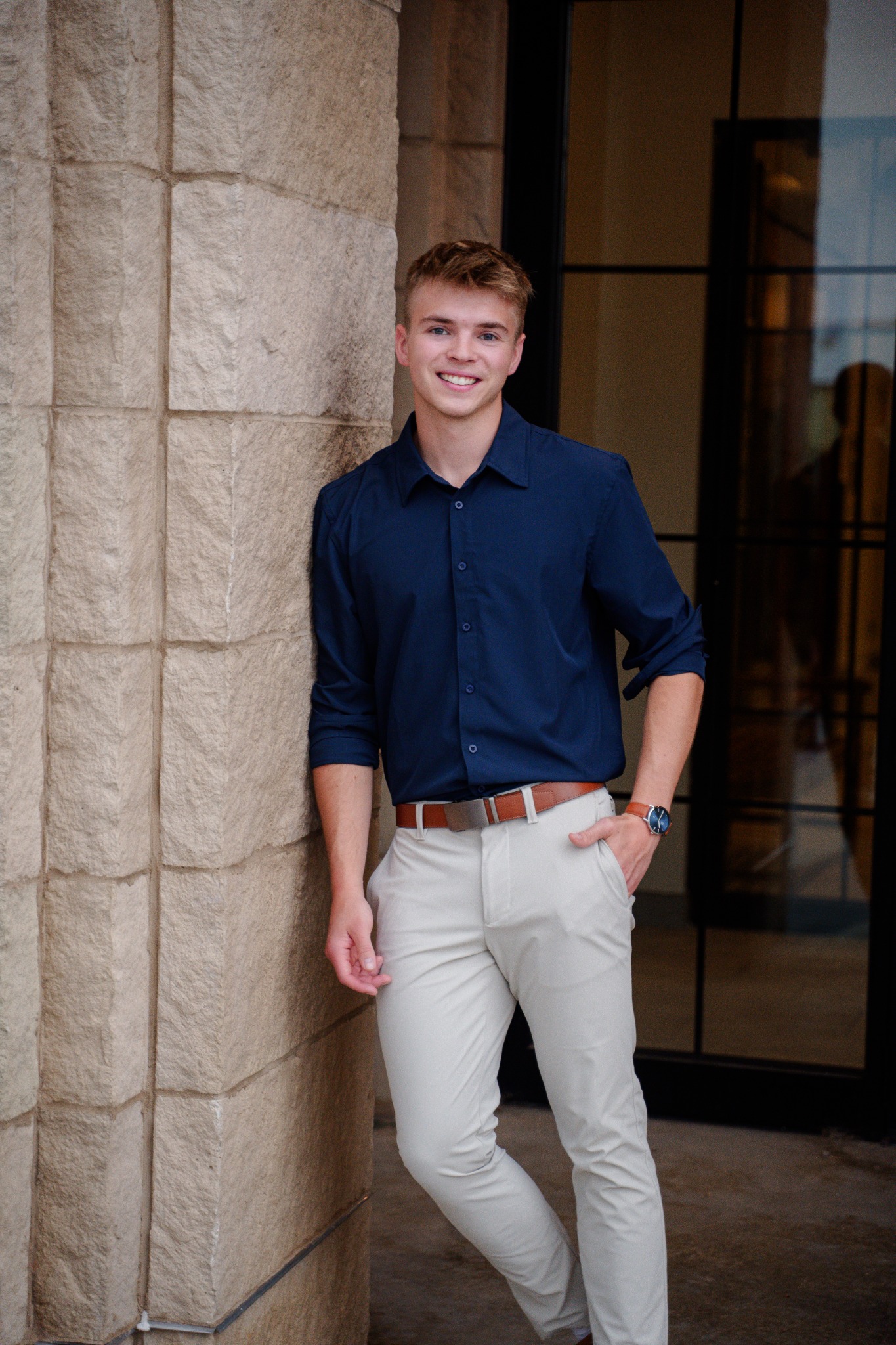 Logan Haburn smiling beside a stone building